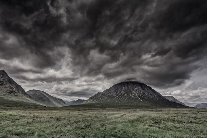 Des montagnes et de champs et le ciel couvert de nuages grises