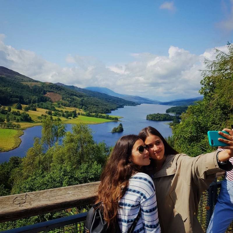 a man and a woman standing in front of a mountain