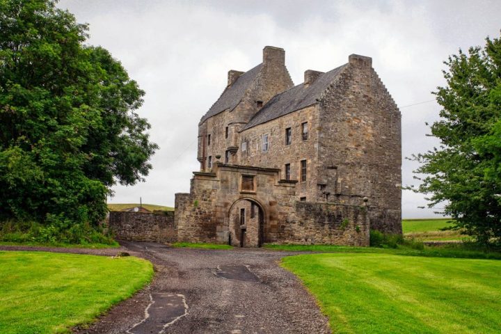 a stone castle next to a brick building