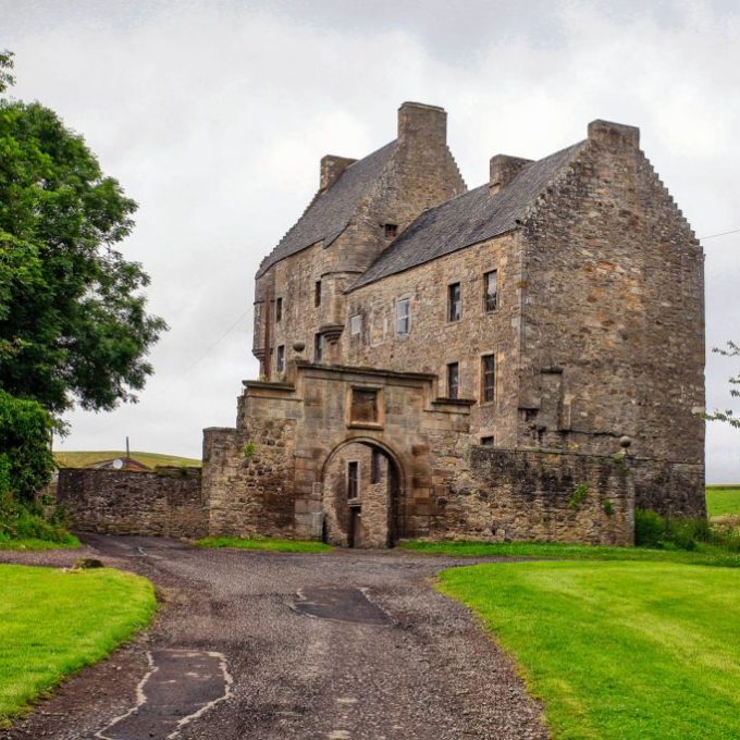 a stone castle next to a brick building