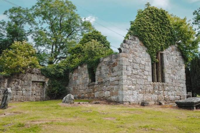 a herd of sheep grazing in front of a brick building